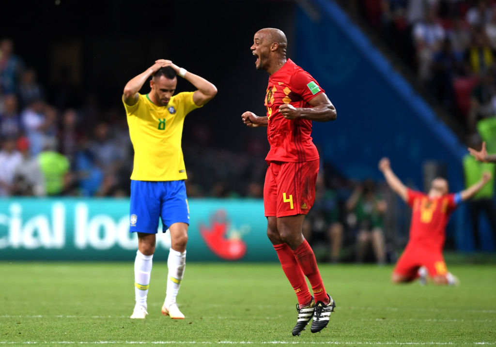 KAZAN, RUSSIA - JULY 06:  Renato Augusto of Brazil looks dejected as Vincent Kompany of Belgium celebrates following the 2018 FIFA World Cup Russia Quarter Final match between Brazil and Belgium at Kazan Arena on July 6, 2018 in Kazan, Russia.  (Photo by Laurence Griffiths/Getty Images)
