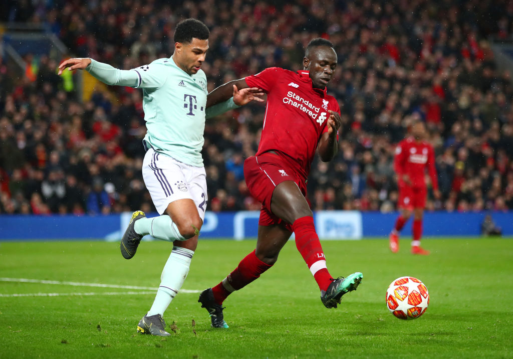 LIVERPOOL, ENGLAND - FEBRUARY 19:  Sadio Mane of Liverpool battles with Serge Gnabry of Bayern Munich during the UEFA Champions League Round of 16 First Leg match between Liverpool and FC Bayern Muenchen at Anfield on February 19, 2019 in Liverpool, England. (Photo by Clive Brunskill/Getty Images)