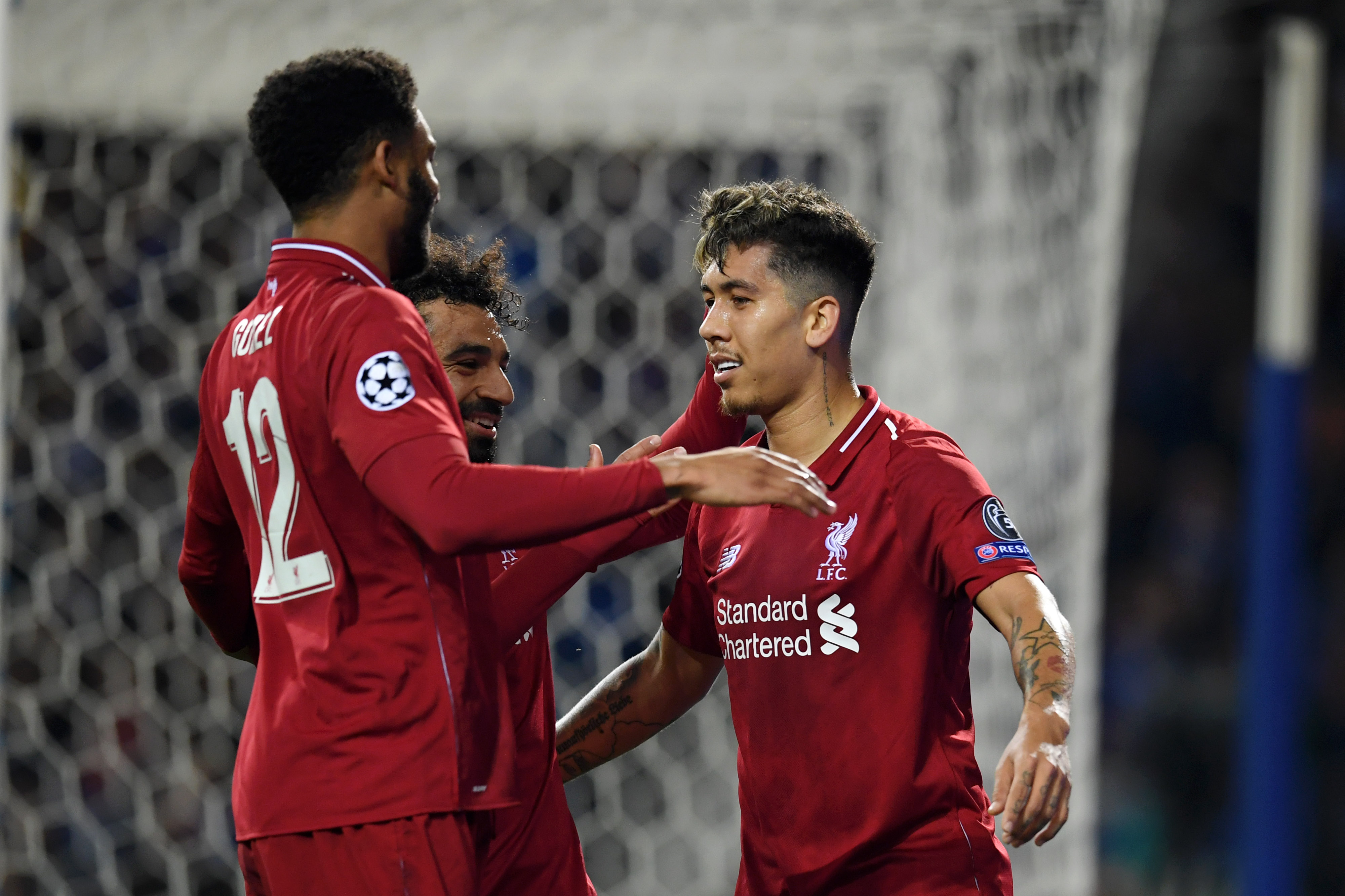 PORTO, PORTUGAL - APRIL 17:  Roberto Firmino of Liverpool celebrates with teammates Mohamed Salah and Joe Gomez after scoring his team's third goal during the UEFA Champions League Quarter Final second leg match between Porto and Liverpool at Estadio do Dragao on April 17, 2019 in Porto, Portugal. (Photo by Matthias Hangst/Getty Images)